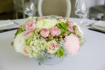 A closeup of a bouquet made of white, green and pink flowers whi