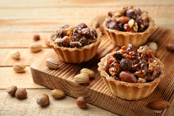 Delicious nut cakes on wooden table