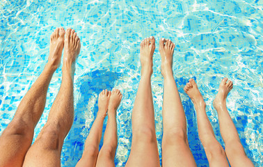 Legs on water background. Family in swimming pool