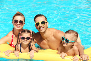 Happy family in swimming pool at water park