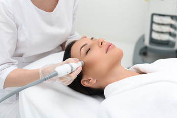 Young woman getting cavitation skin care treatment