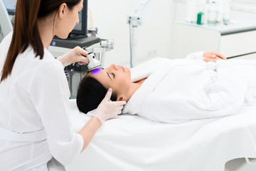 Concentrated cosmetologist doing skin care treatment