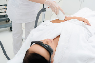 Professional cosmetologist doing ultrasound massage