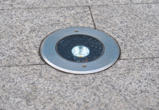 Outdoor Lighting. Garden lighting installed in stone pavement. Stone path to the house with night illumination.