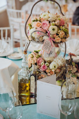 Delicate rose bouquets stand on the tired dish on a dinner table