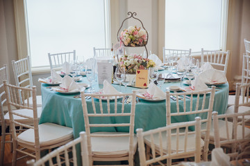 Festive served dinner table covered with mint cloth