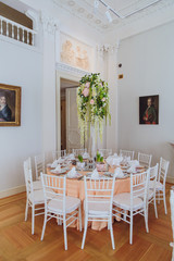 Fototapeta na wymiar White garlands hang from the green bouquet which stands on the o
