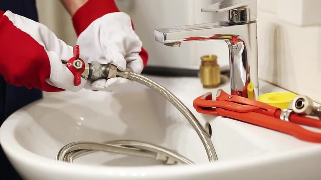 plumber screwing plumbing fittings in bathroom