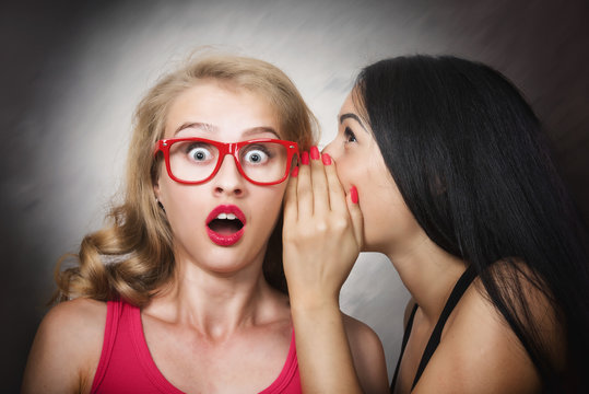 Woman sharing secret with her friend