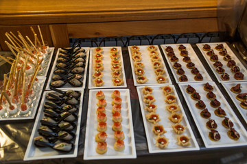 Sea snacks stand in baked baskets on square serving dishes