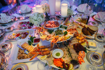 Tasty appetizers made of sea products lie on the white plates