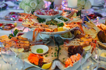 Shrimps hang from the dish with appetizers made of sea products