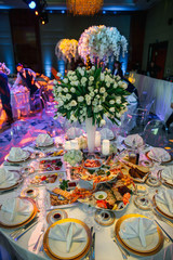 A look from above on a round dinner table served with appetizers
