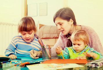 Obraz premium Woman and children together drawing with pencils
