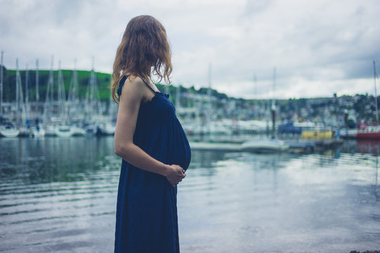 Young pregnant woman by the harbor