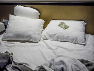Fototapeta na wymiar Tips at the bed for the housekeeper in hotel