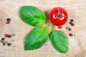 Fresh basil and tomato on wooden background.