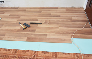 Installing wooden laminate flooring.