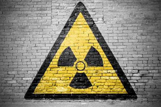 Ziegelsteinmauer mit Warnzeichen Warnung vor radioaktiven Stoffen Graffiti