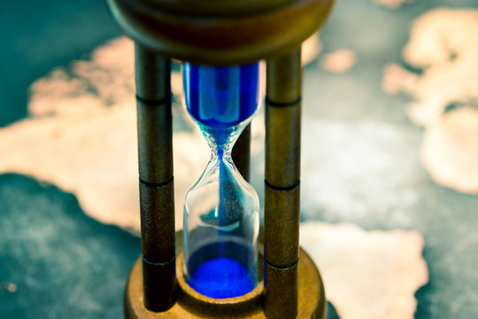 Close up of hourglass against grunge world map
