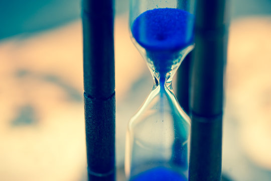 Close up of hourglass against grunge world map
