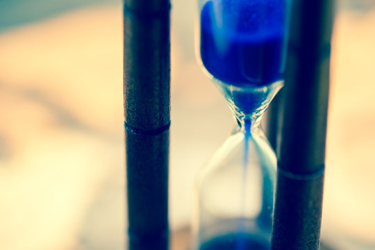 Close up of hourglass against grunge world map