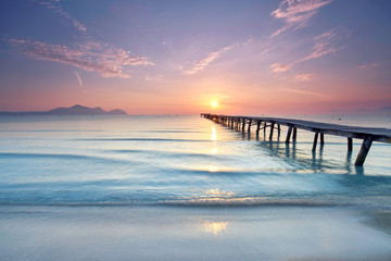 Fototapeta na wymiar Sonnenaufgang über dem alten Holzsteg am Strand
