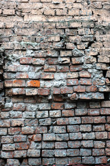 Old destroyed red brick wall as background vertical view closeup