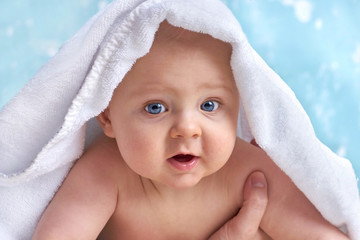 neugieriges Baby mit Badehandtuch