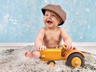 kleines Baby spielt mit Holzspielzeug, lachend, retro © Jenny Sturm