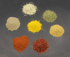 Various spices on black stone surface