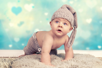 Baby beim Krabbeln, Baby mit Mütze