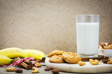 Cookie and vegan milk from nuts in glass jar with various nuts,