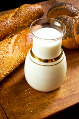 Freshly baked bread with milk on a wooden table