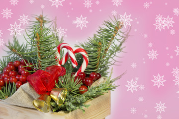 christmas decoration- tree branches , golden bells,sweets and red holly berries in the wooden box   with snowflakes