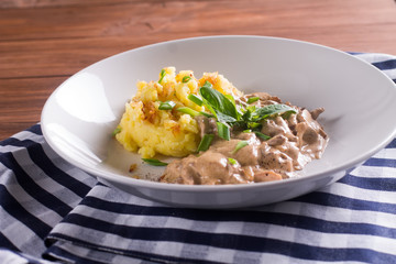 говядина по-строгановски с картофельным пюре, украшена зеленью