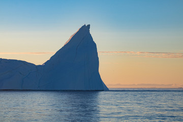 Fototapeta na wymiar The sunset with icebergs on the ocean in Ilulissat, Greenland