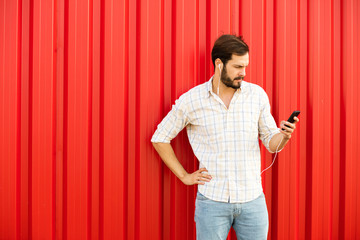 handsome man smiling with cellphone on red background