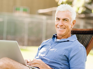 Obraz premium Senior man with notebook sitting in the park