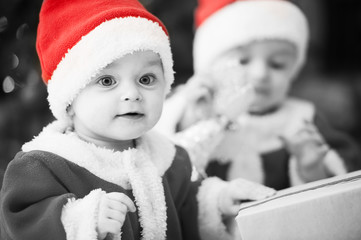 kids dressed as Santa Claus at Christmas tree with gifts