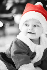 kids dressed as Santa Claus at Christmas tree with gifts