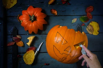 Foto op Plexiglas Carve a pumpkin for halloween or autumn decoration on blue rustic wood © Maren Winter