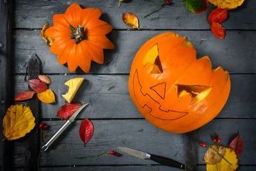 Foto op Plexiglas Preparing a carved pumpkin for halloween, autumn decoration tinker on gray rustic wood © Maren Winter
