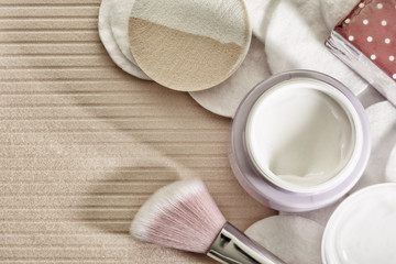 Tone cream and cotton pads on a pink background.