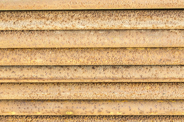 Old, rusty, dirty pipes are piled horizontally