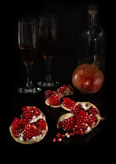 Segments of pomegranate and the whole fruit on a black background