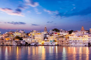 Meubelstickers Evening view of  illuminated houses on lake Pichola in Udaipur © Dmitry Rukhlenko