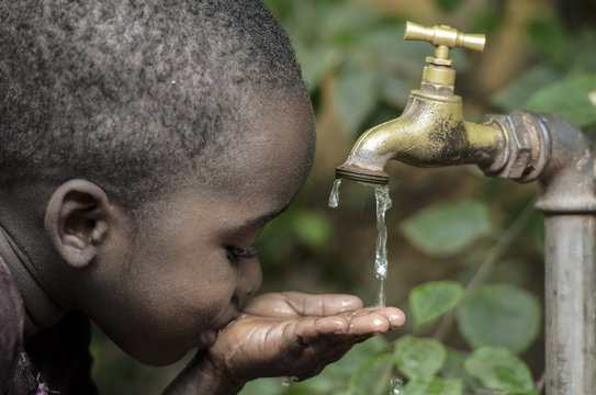 Baby Boy Drinks Water from Tap in a Garden