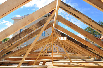 New residential construction home framing against a blue sky. Roofing construction. installation of...