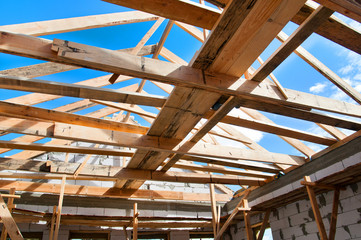 New residential construction home framing against a blue sky. Roofing construction. installation of insulation wool. white building blocks. unfinished plaster.